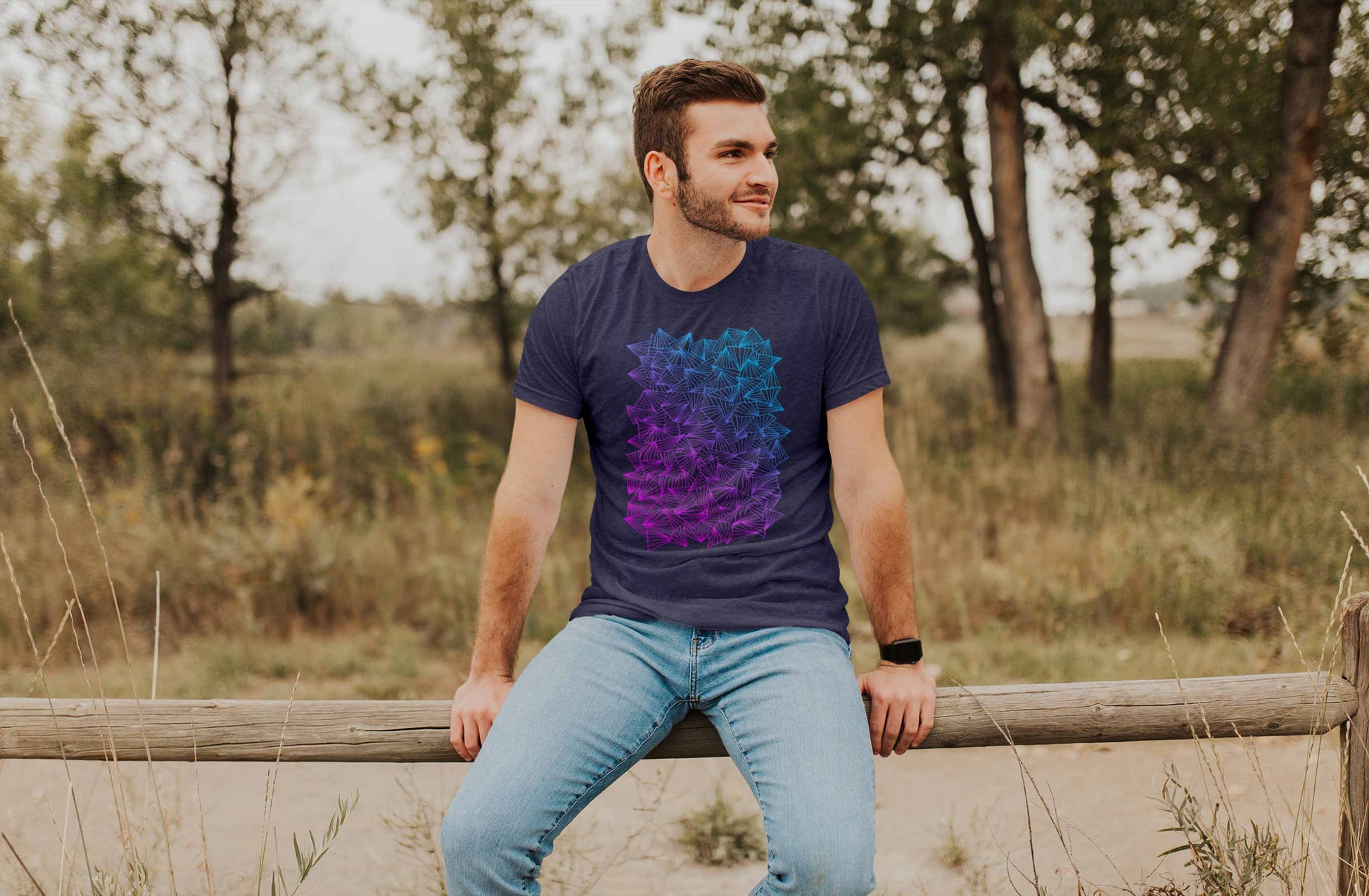Model posing in a field with gaggle of triangles gradient design on heather midnight navy unisex t-shirt.