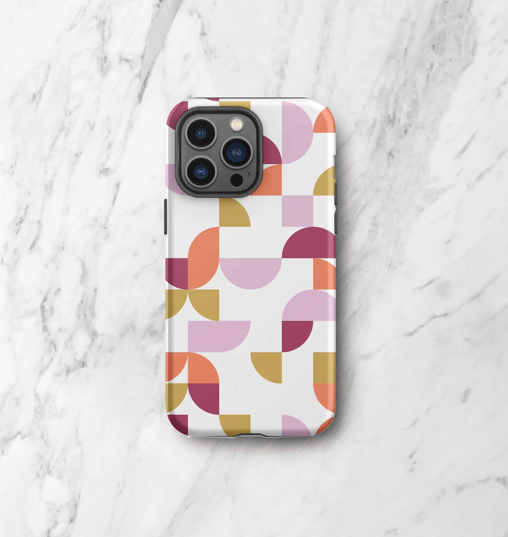 Front view of iPhone tough case in Geometria I Sunset design on a marble countertop