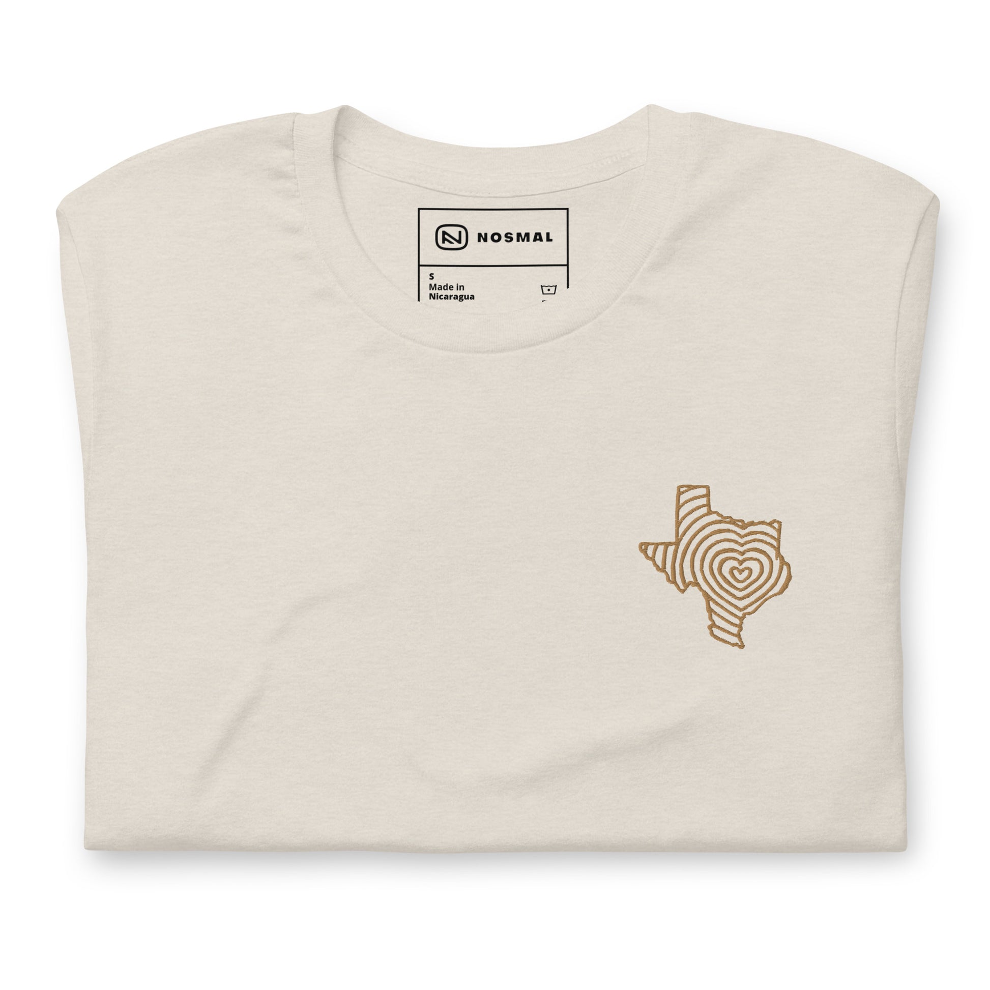Top down view of heartbeat of texas gold embroidered design on heather dust unisex t-shirt.